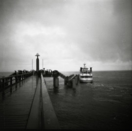 A Boat by a Pier on a Sunday Full of Rain